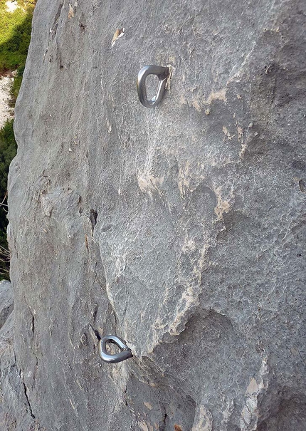Fix arrampicata Sardegna - Fittone inox di calata di una sosta alla francese, chiaramente consumato dalla corda