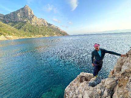 Marinaio di foresta - Pedra Longa, Baunei, Sardinia - Enrico Mosetti at the start of Marinaio di foresta, Pedra Longa, Baunei, Sardinia. Note the mooring ring at the base of the route. In the background Punta Giradilli.