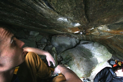 Fotografare l'azione dell'arrampicata - Enrico Baistrocchi  riflessivo sotto un boulder in val Verzasca