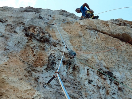 Monte Santu, Baunei, Sardegna - Blu Oltremare. Rolando Larcher dopo l'obbligatorio di 7b del tiro di 8a, con in mano la soluzione della via.