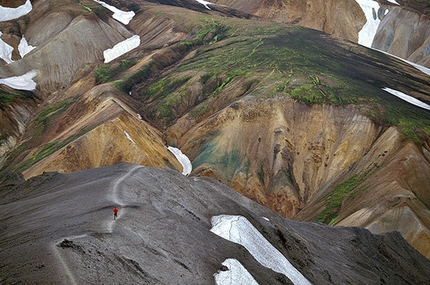 PatitucciPhoto - Runner dwarfed by the large, colorful landscape on an uphill slog in Blahnukur-Landmannalaugar, Iceland.