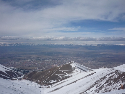 Kaçkar Dagi scialpinismo, Turchia - Dopo un primo tratto riusciamo a deviare dalla pista per raggiungere un pendio che ci porta in vetta a 3250m con un bel panorama su una distesa di montagne bianche più basse e alle spalle la città con la catena delle Kaçkar o Black Sea Mountains che fanno da cornice.