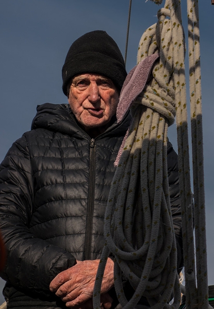 Greenland, Baffin Island - Our Captain Reverend Bob Shepton studying what strategy to use
to undo our triple lines anchored to shore while the wind is blowing us on rocks.