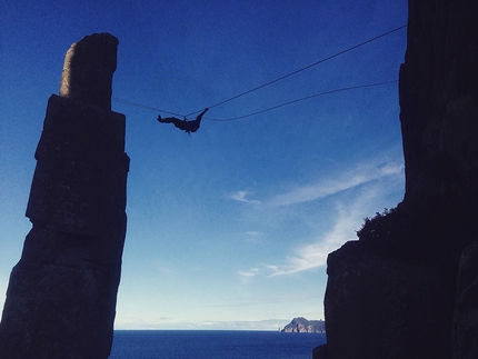 Paul Pritchard, Totem Pole, Tasmania - Paul Pritchard making the Tyrollean traverse to return to mainland after having climbed The Totem Pole in Tasmania