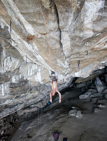 Adam Ondra, Flatanger, Norway - Adam Ondra resting with a knee-bar before one of the cruxes on Project Hard at Flatanger in Norway. The climb has three distinct boulder cruxes: 8c, 8B and 7C+. The route is now called Silence