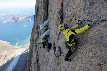 Greenland - Roger Schäli starts up the headwall at first light, belayed by Simon Gietl and Daniel Koppin their portaledges.