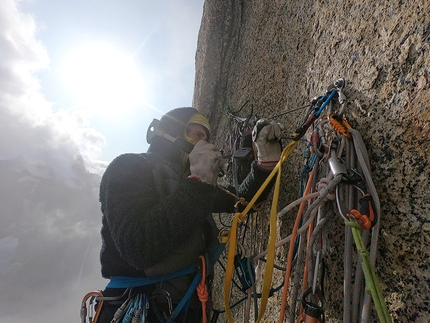 Federica Mingolla, Edoardo Saccaro, Nalumasortoq, Tasermiut Fjord, Groenlandia - Edoardo Saccaro pianta un fix con il pianta spit perché le batterie stanno per finire ed é meglio risparmiarle per arrivare in cima - durante l'apertura di La Cura con Federica Mingolla sul Nalumasortoq, Tasermiut Fjord, Groenlandia (08/2019)