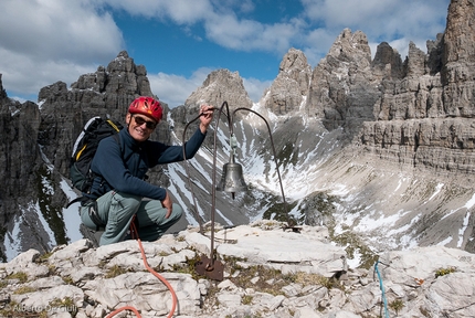 Campanile di Val Montanaia, Dolomiti - Giorgio Bernasconi accanto alla famosa campana in cima al Campanile di Val Montanaia, Dolomiti friulane