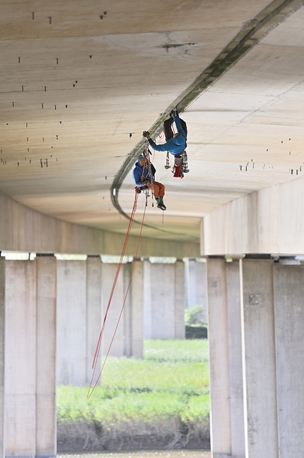 Tom Randall, Pete Whittaker, motorway bridge  - Tom Randall and Pete Whittaker climbing The Great Rift on the M5 motorway bridge above River Exe in the UK. Over four days and nights, bivouacking in a free hanging portaledge amidst the roaring din of traffic, the pair shoved their hands and feet thousands of times into a crack that vibrated and flexed as delivery trucks rumbled just a few feet overhead. 