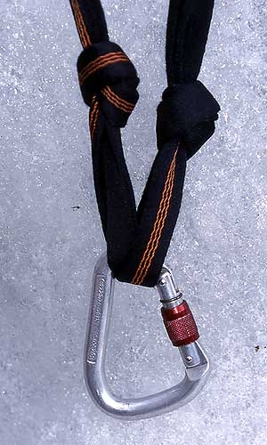 Ice climbing belays - Semi-mobile ice screw belay - Ice climbing belays: 2. The sling must have two overhand knots tied close to the V-point of the belay. Twist the upper section of the sling and place a screwgate carabiner into this loop. Use this carabiner for your belay