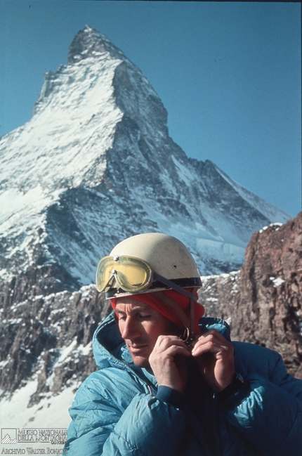 Walter Bonatti - Walter Bonatti sistema il suo fedele casco. Sullo sfondo, in ombra, la grande nord del Cervino